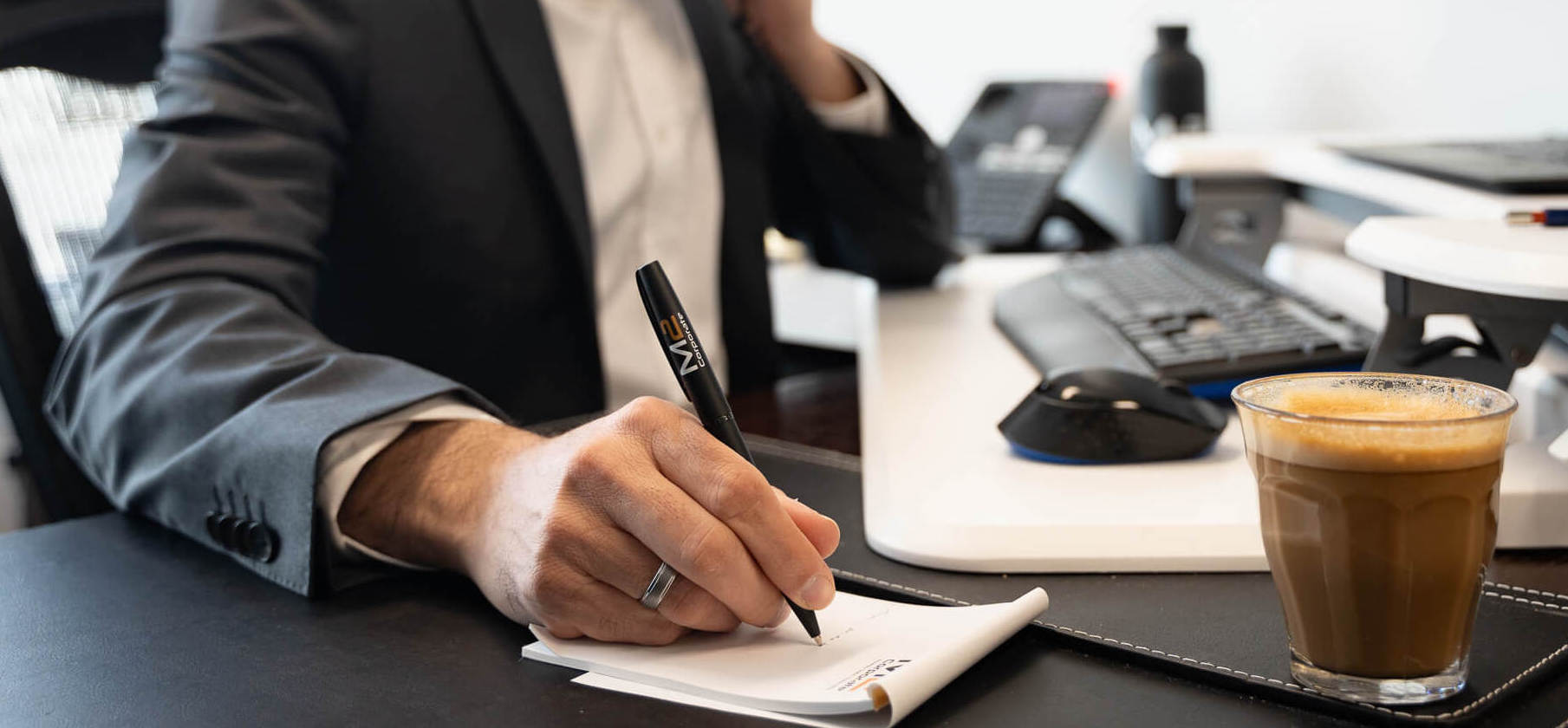 Business accountant taking a note over a free consultation with a client with a cup of coffee on the desk