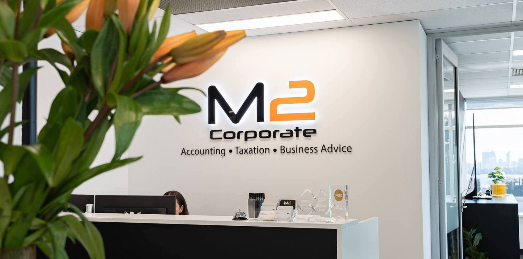 M2 Corporate's office signage and reception desk with business accountant and business advisory awards on the desk