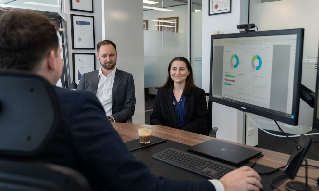 Accountant explaining to a man and woman how accountants help businesses succeed